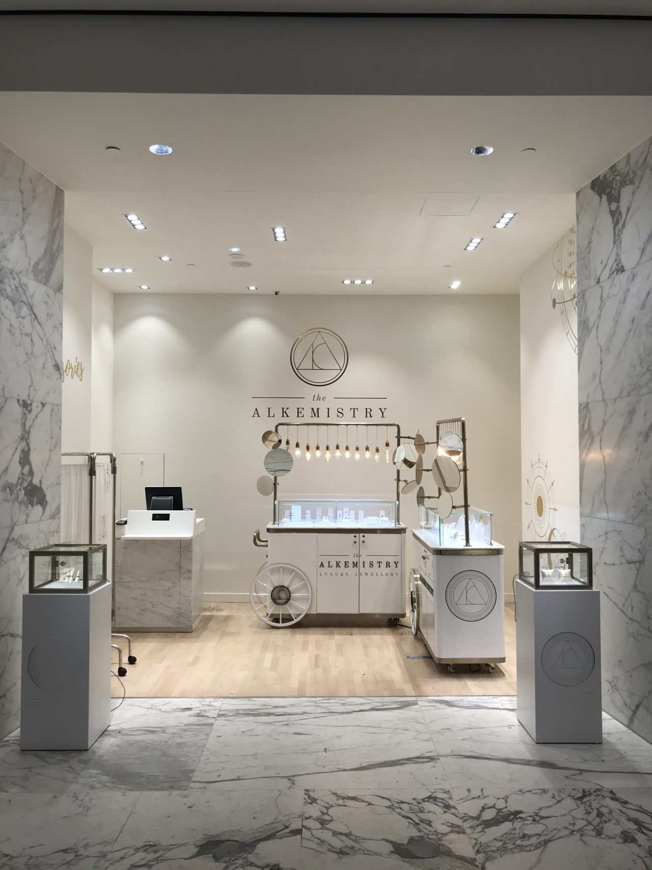 The Alkemistry store with various glass displays and marble patterned walls.